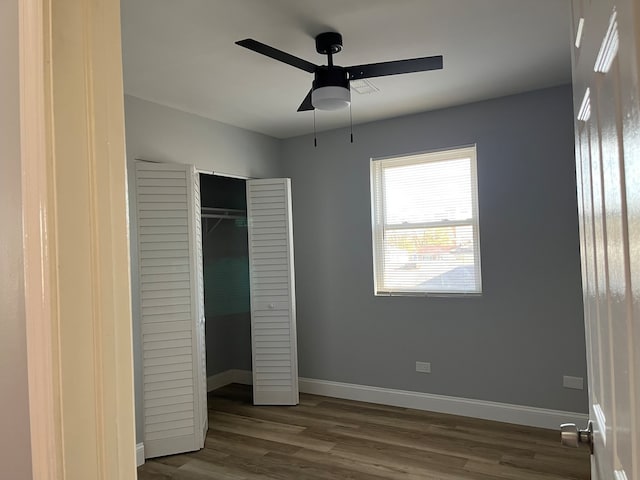 unfurnished bedroom with ceiling fan, a closet, and dark hardwood / wood-style floors