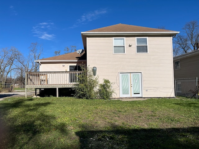 back of property featuring a lawn and a deck