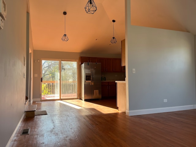 unfurnished living room with high vaulted ceiling and dark wood-type flooring