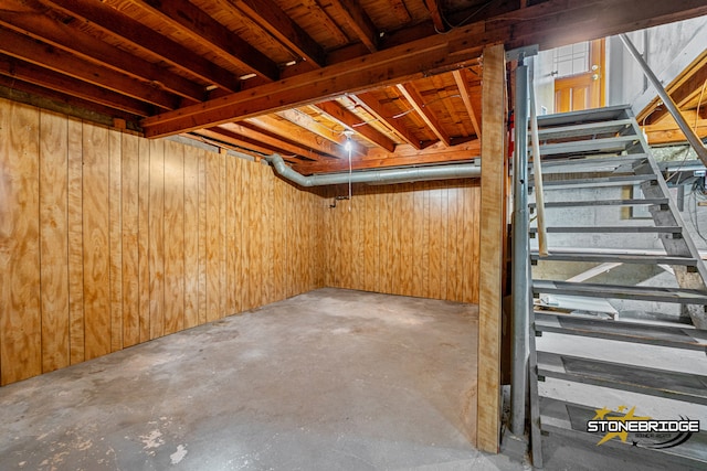 basement featuring wooden walls