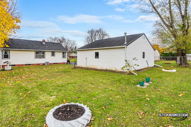 rear view of property featuring cooling unit and a yard