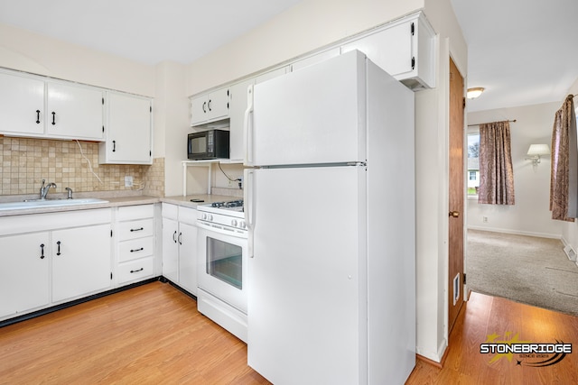 kitchen featuring light wood-type flooring, backsplash, white appliances, sink, and white cabinets