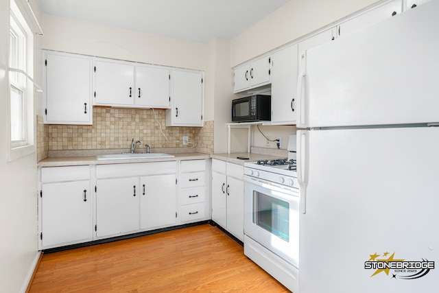 kitchen with white appliances, sink, light wood-type flooring, tasteful backsplash, and white cabinetry