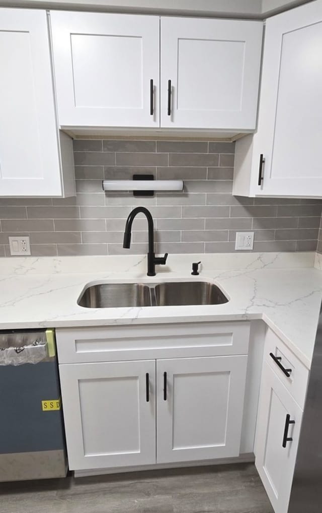 kitchen featuring white cabinetry, sink, dishwasher, and wood-type flooring