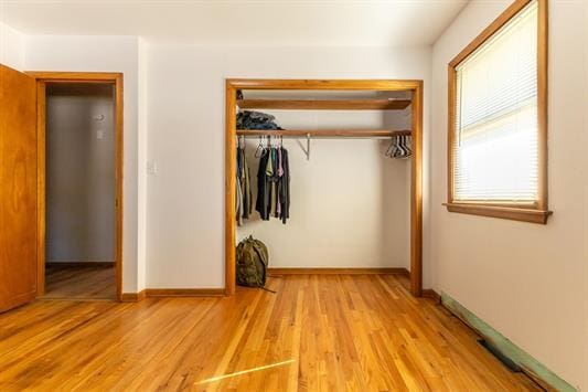 unfurnished bedroom with light hardwood / wood-style floors and a closet