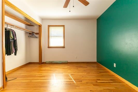 unfurnished bedroom with ceiling fan, light wood-type flooring, and a closet