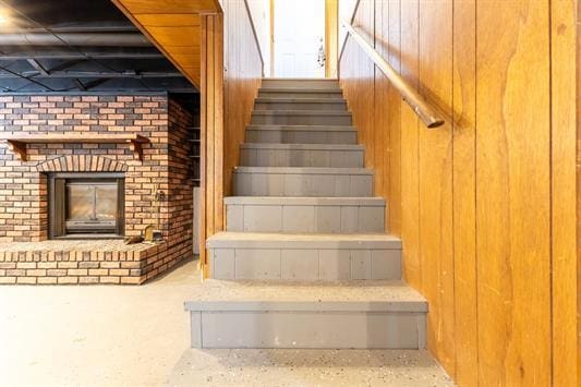 staircase with a brick fireplace