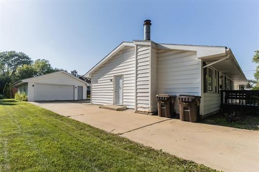 view of side of home with a lawn, an outbuilding, and a garage