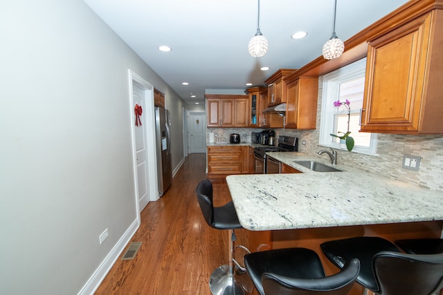 kitchen with appliances with stainless steel finishes, tasteful backsplash, sink, dark hardwood / wood-style floors, and hanging light fixtures