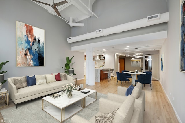 living room featuring light hardwood / wood-style flooring and ceiling fan