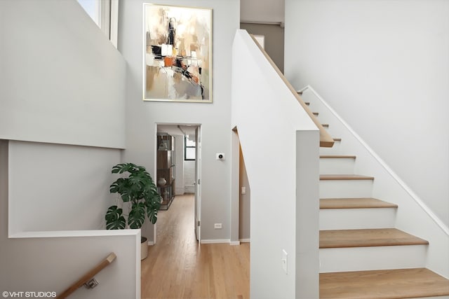 stairway with hardwood / wood-style flooring and a healthy amount of sunlight