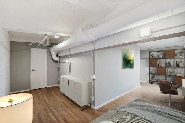 basement featuring radiator heating unit and light wood-type flooring