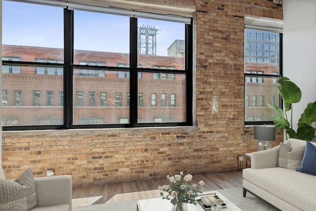 living room featuring wood-type flooring and brick wall