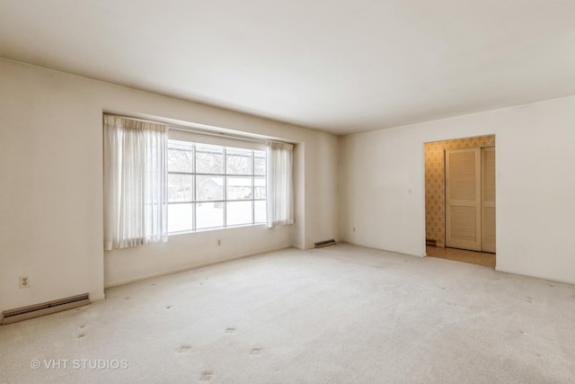 carpeted empty room featuring a baseboard radiator