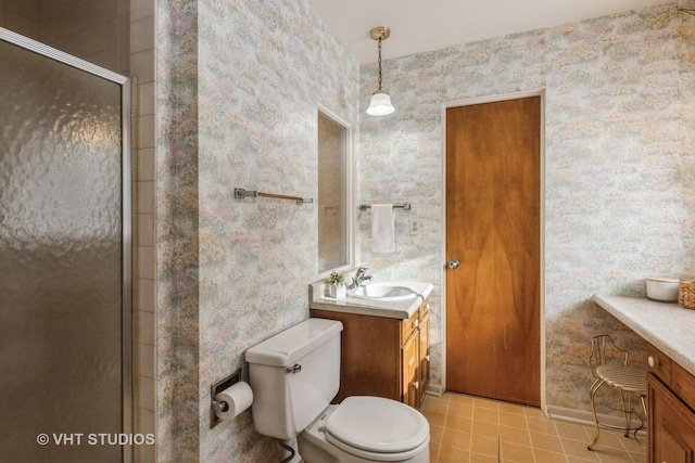 bathroom with an enclosed shower, vanity, and toilet