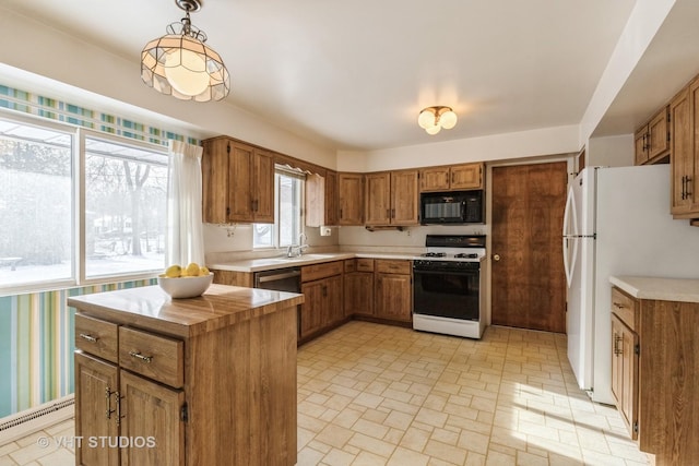 kitchen with white appliances, decorative light fixtures, and sink