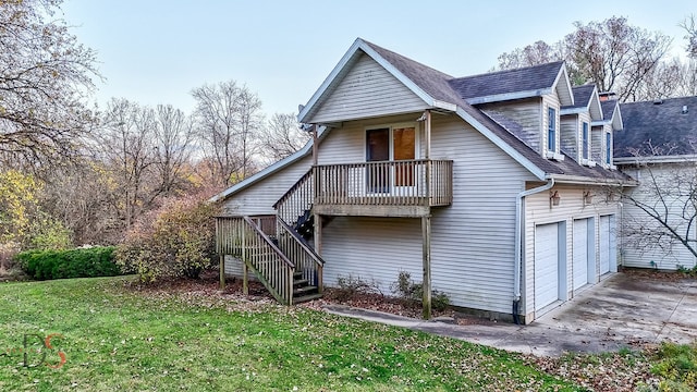 back of property featuring a garage and a yard