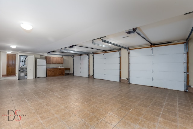 garage with white fridge and a garage door opener