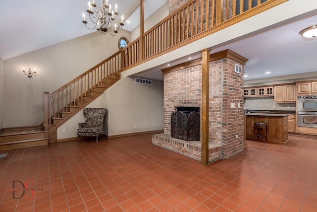 unfurnished living room featuring a fireplace, high vaulted ceiling, tile patterned floors, and a notable chandelier