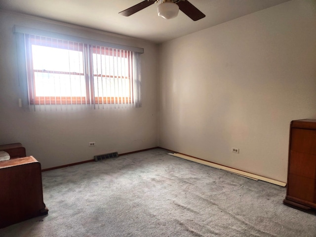 unfurnished room with light colored carpet, plenty of natural light, and ceiling fan