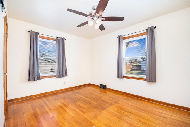 unfurnished room with ceiling fan, hardwood / wood-style floors, and a healthy amount of sunlight