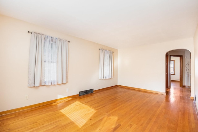 empty room with hardwood / wood-style floors and plenty of natural light