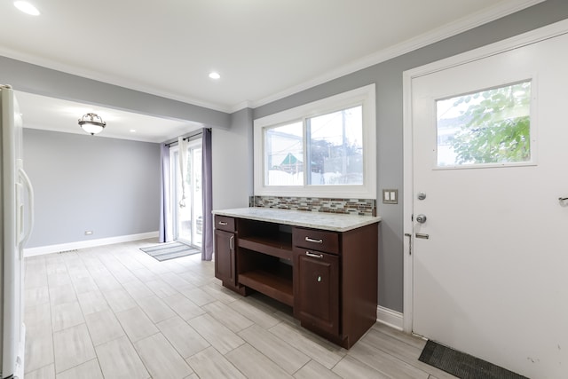 kitchen featuring decorative backsplash, dark brown cabinets, white fridge, and crown molding