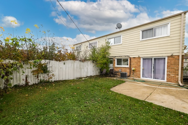 rear view of house featuring a yard, cooling unit, and a patio area