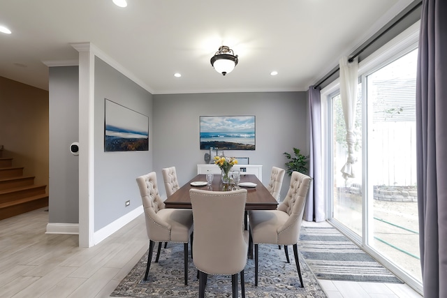 dining space with light hardwood / wood-style flooring and ornamental molding