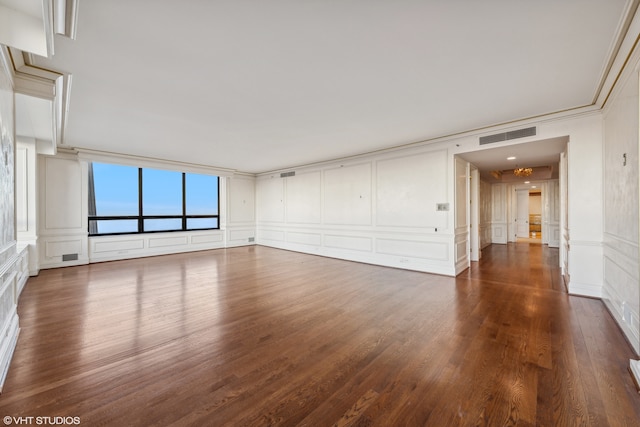 spare room with dark hardwood / wood-style flooring and crown molding