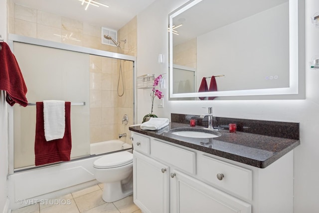 full bathroom with tile patterned flooring, bath / shower combo with glass door, vanity, and toilet