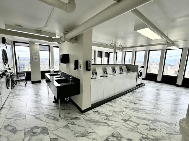 living room with washing machine and dryer, stacked washer and clothes dryer, and plenty of natural light