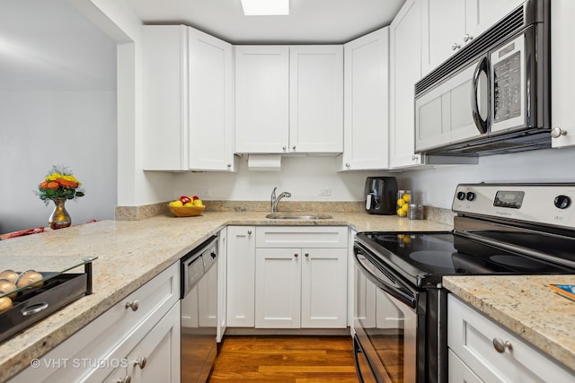 kitchen featuring sink, white cabinetry, light stone counters, and appliances with stainless steel finishes