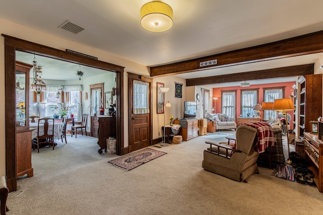 carpeted living room featuring beam ceiling