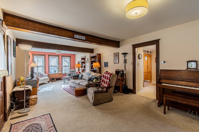 carpeted living room with beamed ceiling