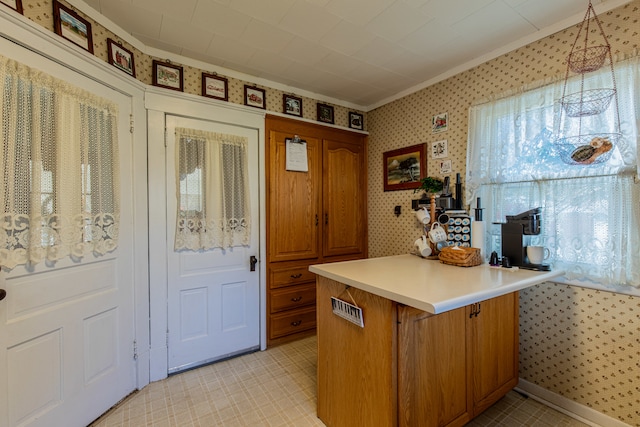 kitchen with pendant lighting, a kitchen breakfast bar, kitchen peninsula, and ornamental molding