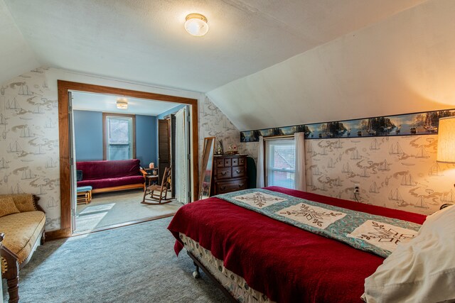 carpeted bedroom featuring a textured ceiling and vaulted ceiling