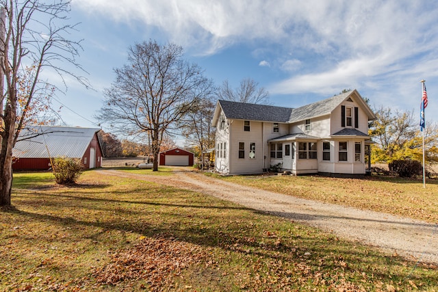 view of side of property with a lawn, a garage, and an outdoor structure