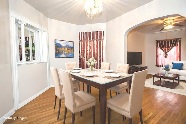 dining space featuring ceiling fan with notable chandelier and hardwood / wood-style flooring