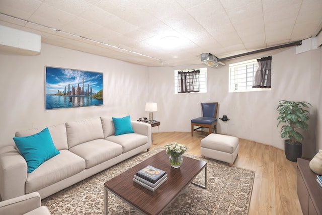 living room with a wall mounted air conditioner and light wood-type flooring