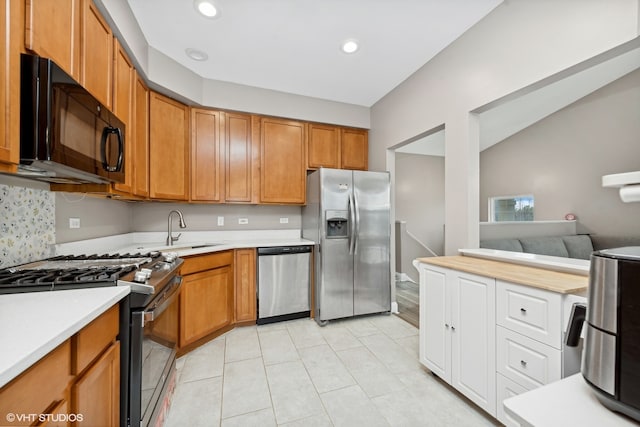 kitchen with light tile patterned flooring, stainless steel appliances, and sink