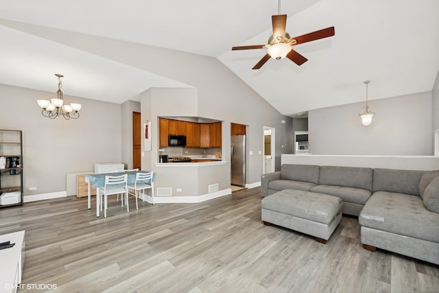 living room featuring light hardwood / wood-style flooring, high vaulted ceiling, and ceiling fan with notable chandelier