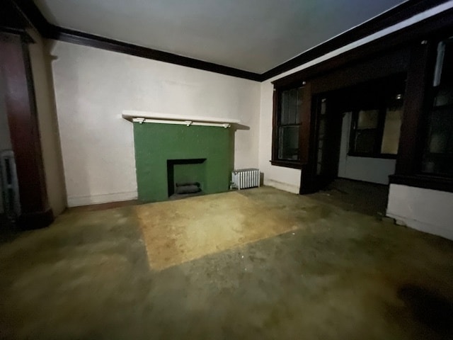 unfurnished living room featuring crown molding and radiator