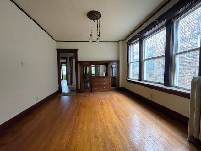 unfurnished dining area featuring a notable chandelier and light wood-type flooring