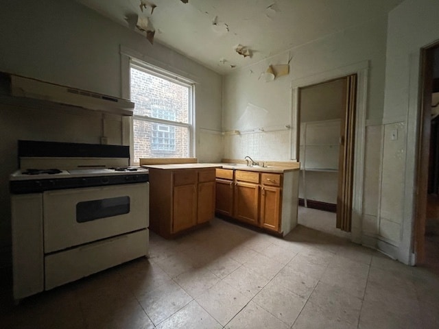 kitchen with white gas range and sink