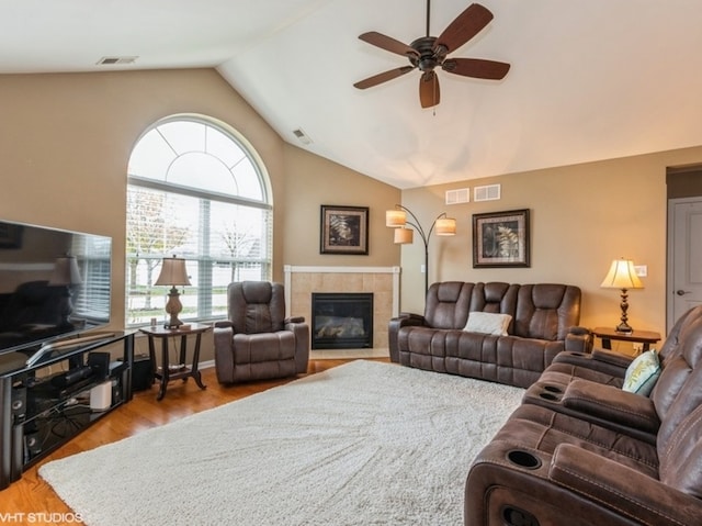 living room featuring a fireplace, hardwood / wood-style floors, ceiling fan, and lofted ceiling