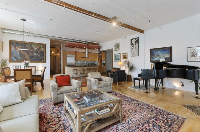 living room featuring beamed ceiling and hardwood / wood-style flooring