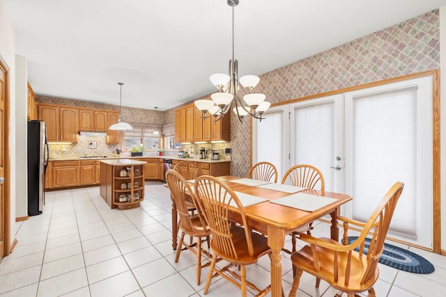 dining space with light tile patterned flooring and a notable chandelier