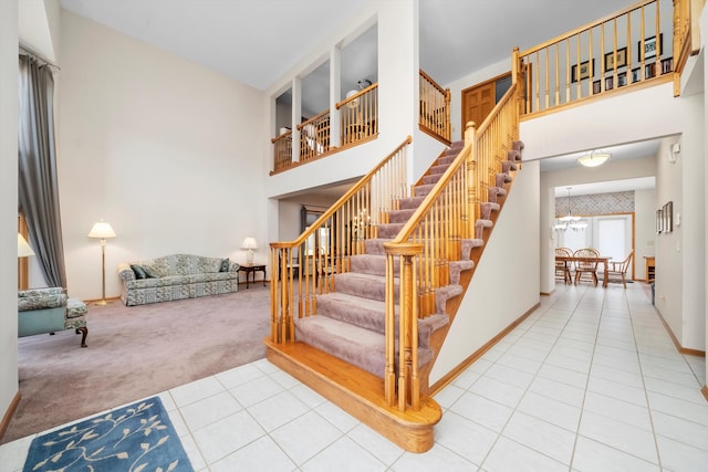 staircase featuring carpet flooring and a high ceiling