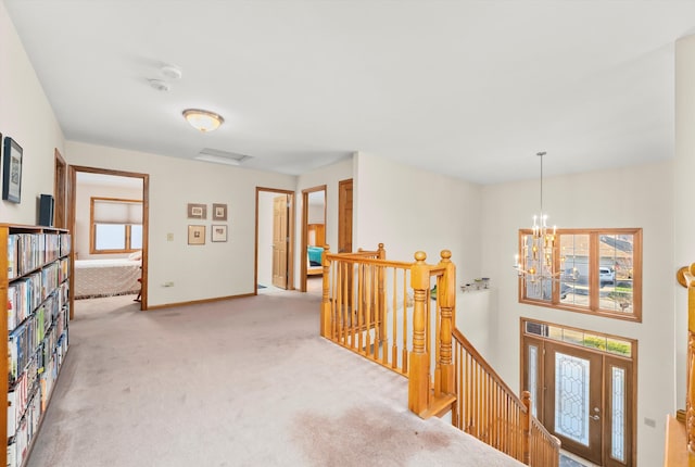 corridor with carpet floors and a notable chandelier